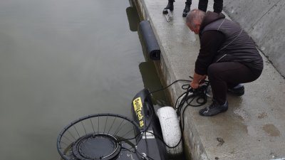 Работещ на пристанището в Ченгене скеле вади контейнера, за да види какво е събрал от дъното